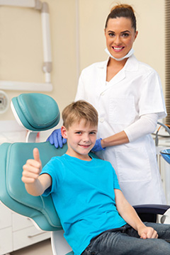 Emergency Dental Insurance in Chicago - Little boy thumb up in dentist office