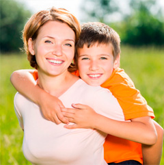 Treating Knocked Out Permanent Tooth in Chicago - Happy mother and son outdoor portrait