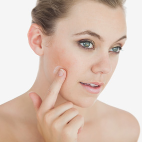 Woman Applying Cream on Face