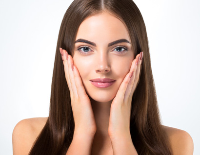 Beautiful woman face closeup hands on skin