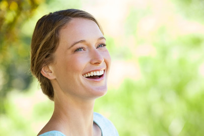 Cheerful thoughtful woman looking away in park