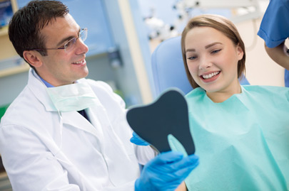 Dentist show teeth to girl with mirror when finished repairing