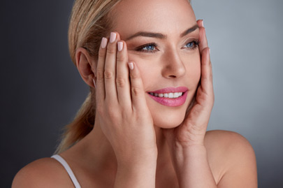 Middle age woman tightening skin on face with hand
