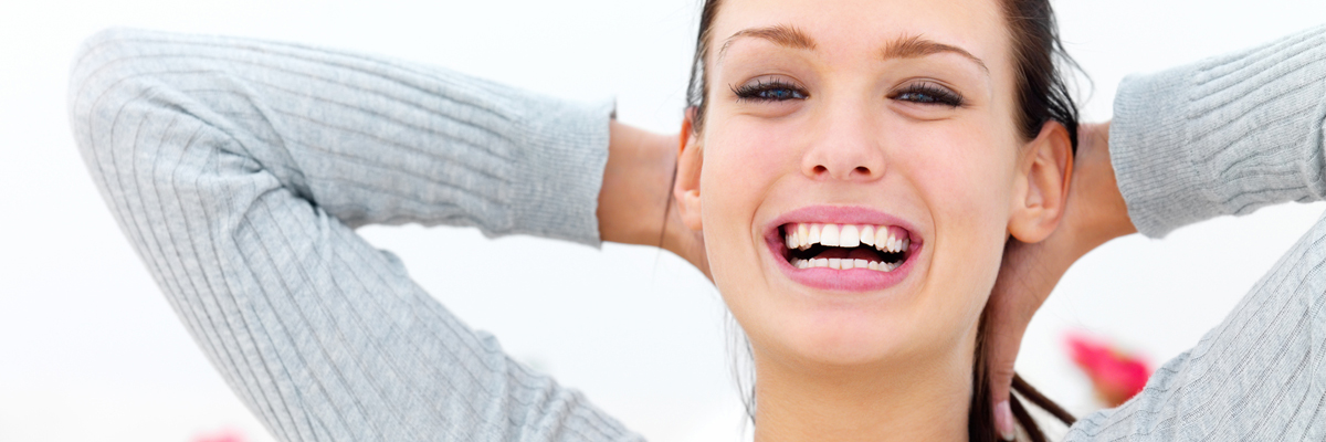 Closeup portrait of happy young woman with hands behind neck