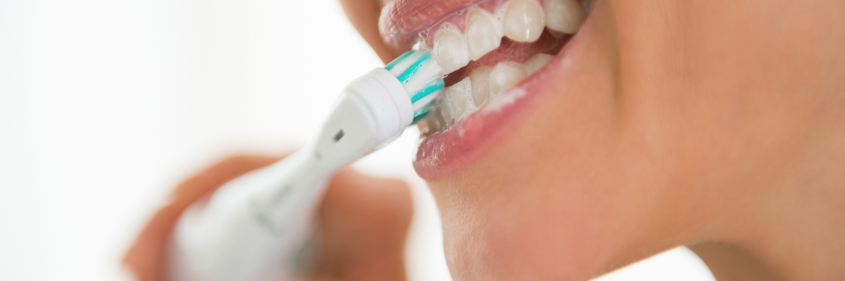 Closeup on young woman brushing teeth