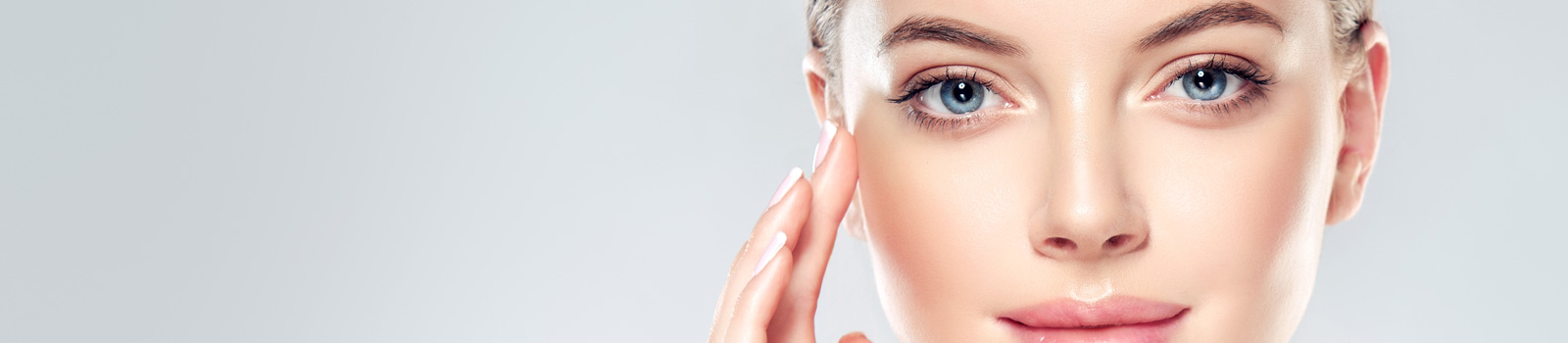 Beautiful Young Woman with Clean Fresh Skin touch own face