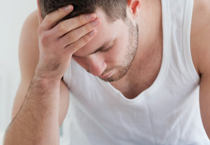 Man suffering from headache with hands on forehead