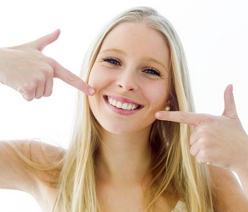 woman pointing at her beautiful teeth